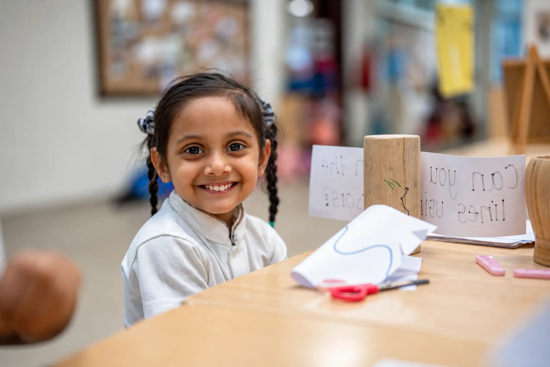 O Level schools in Dubai: smiling young student at her classroom desk