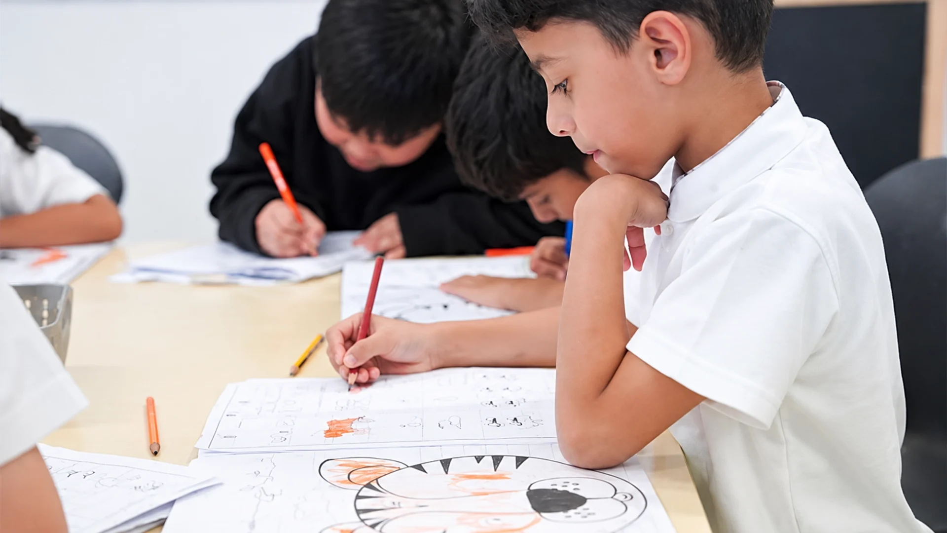 Best British schools in Dubai with fees: primary students completing worksheets in class
