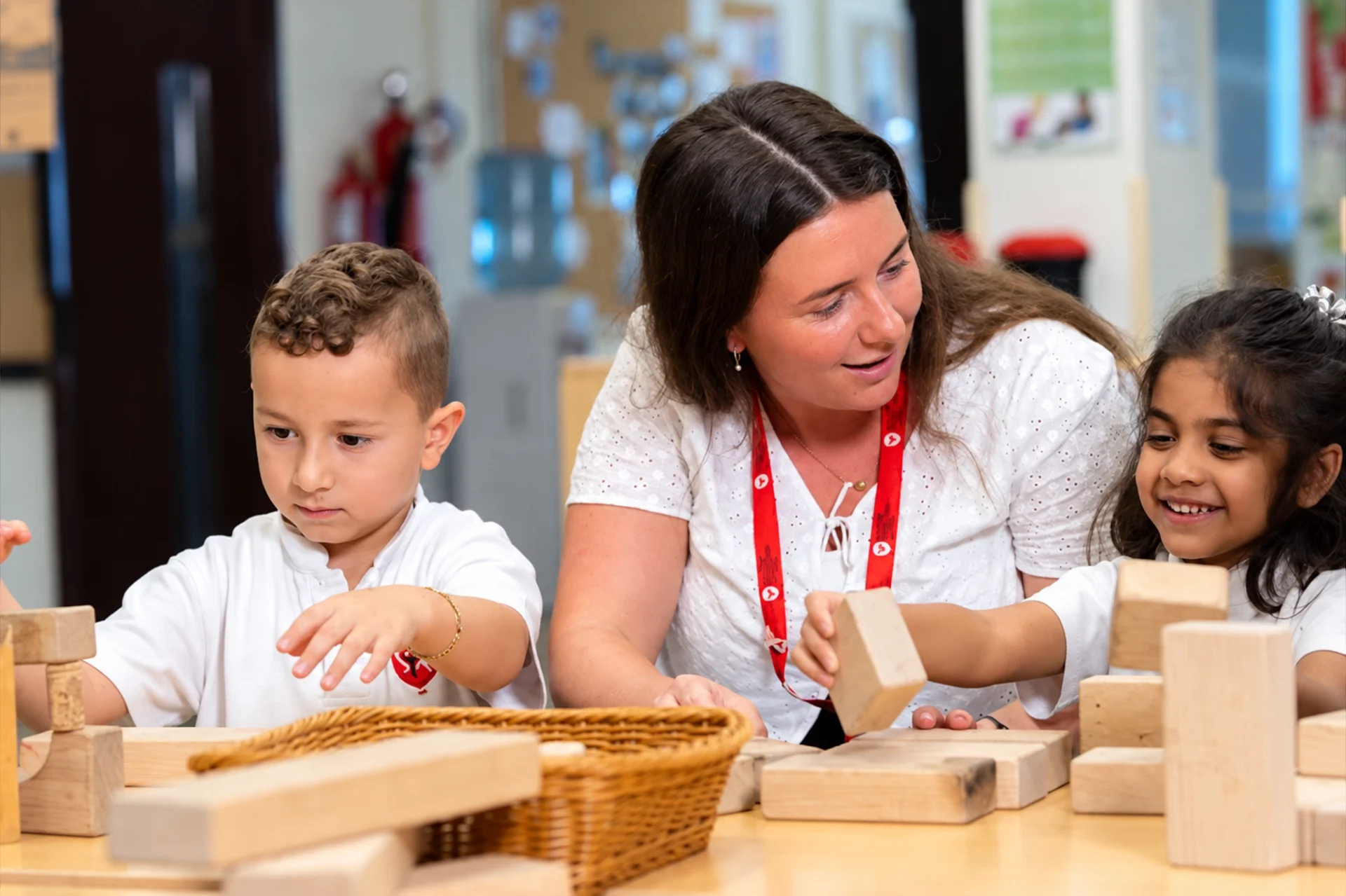 FS1 age in UAE: teacher building blocks with early years students
